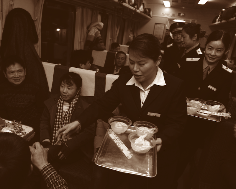 2014年1月31日：在阖家团圆的除夕夜，列车员特意端来热腾腾的饺子，送给尚在旅途中的旅客们吃。郭立亮/摄